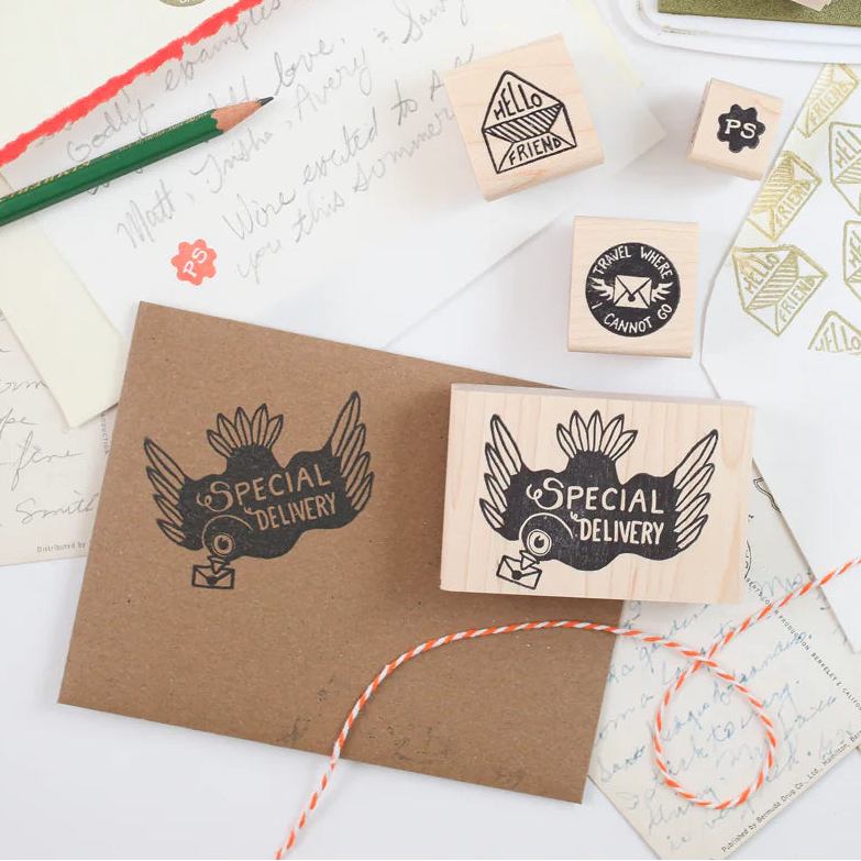 Collection of rubber stamps, ink pads, and stationery items on a white background