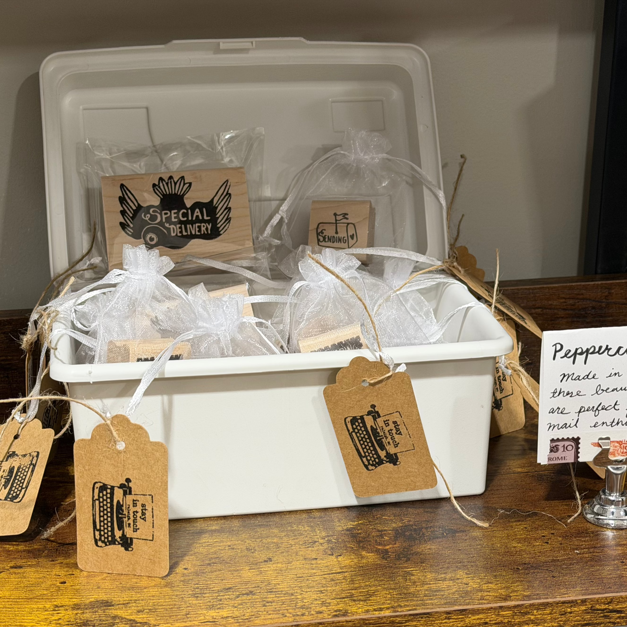 White container with packaged stamps on wood shelf. One stamp says special delivery.
