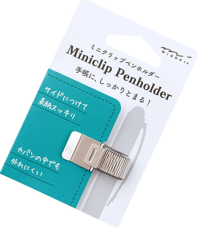 A silver metal Miniclip pen holder with a ribbed textured grip, attached to a white and teal paper backing card with Japanese text and the brand name Midori.